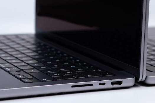 Detailed view of laptop ports and keyboards on a white surface, showcasing modern technology.