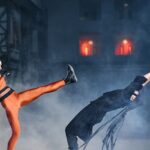 Two cosplayers in a dramatic martial arts duel, showcasing agility and strength.